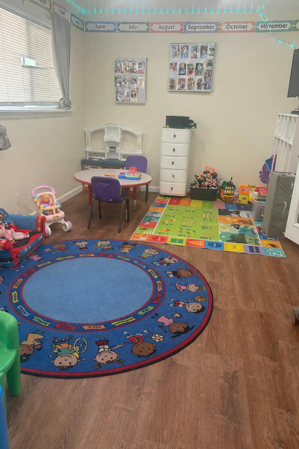 Child's playroom with table, chairs, toy kitchen, and several rugs