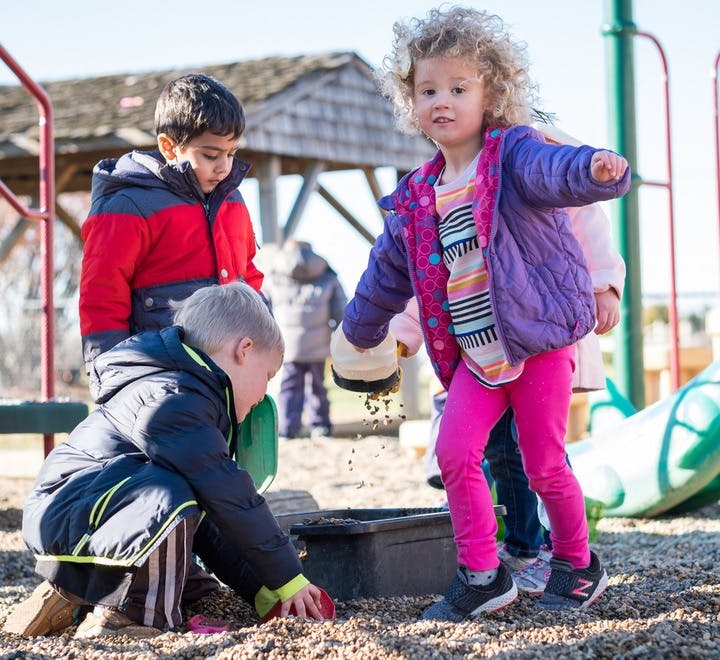 Children playing in a sandbox at a playground
