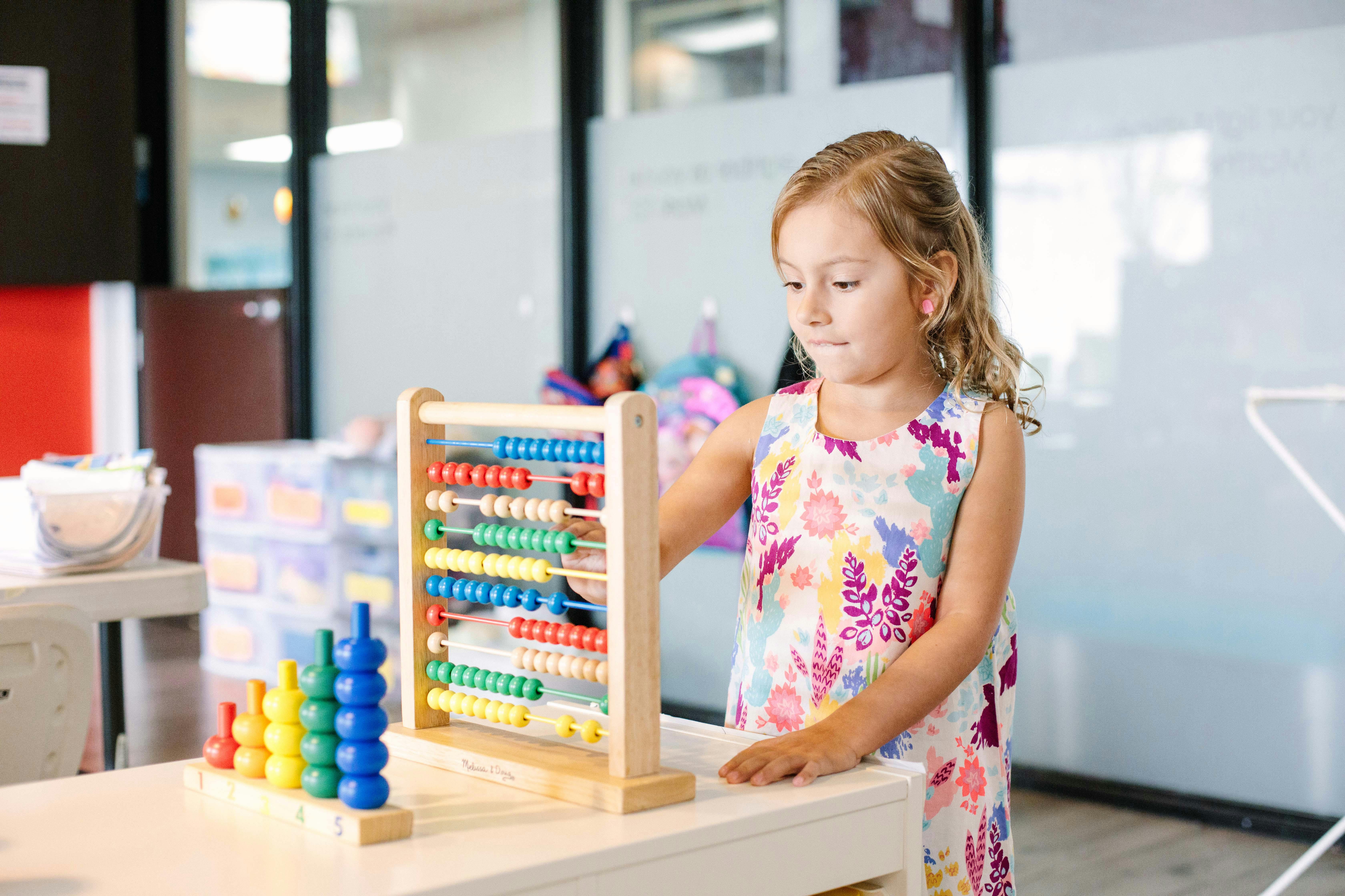 Child playing with an abacus and stacking toy