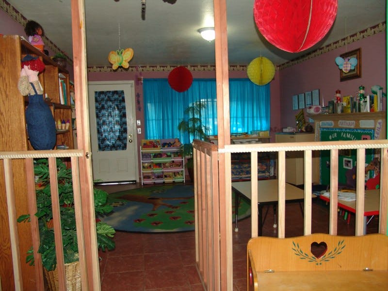 Playroom with wooden railings, colorful rug, and blue curtains