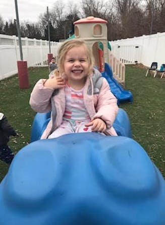 Child sitting on a blue playground toy