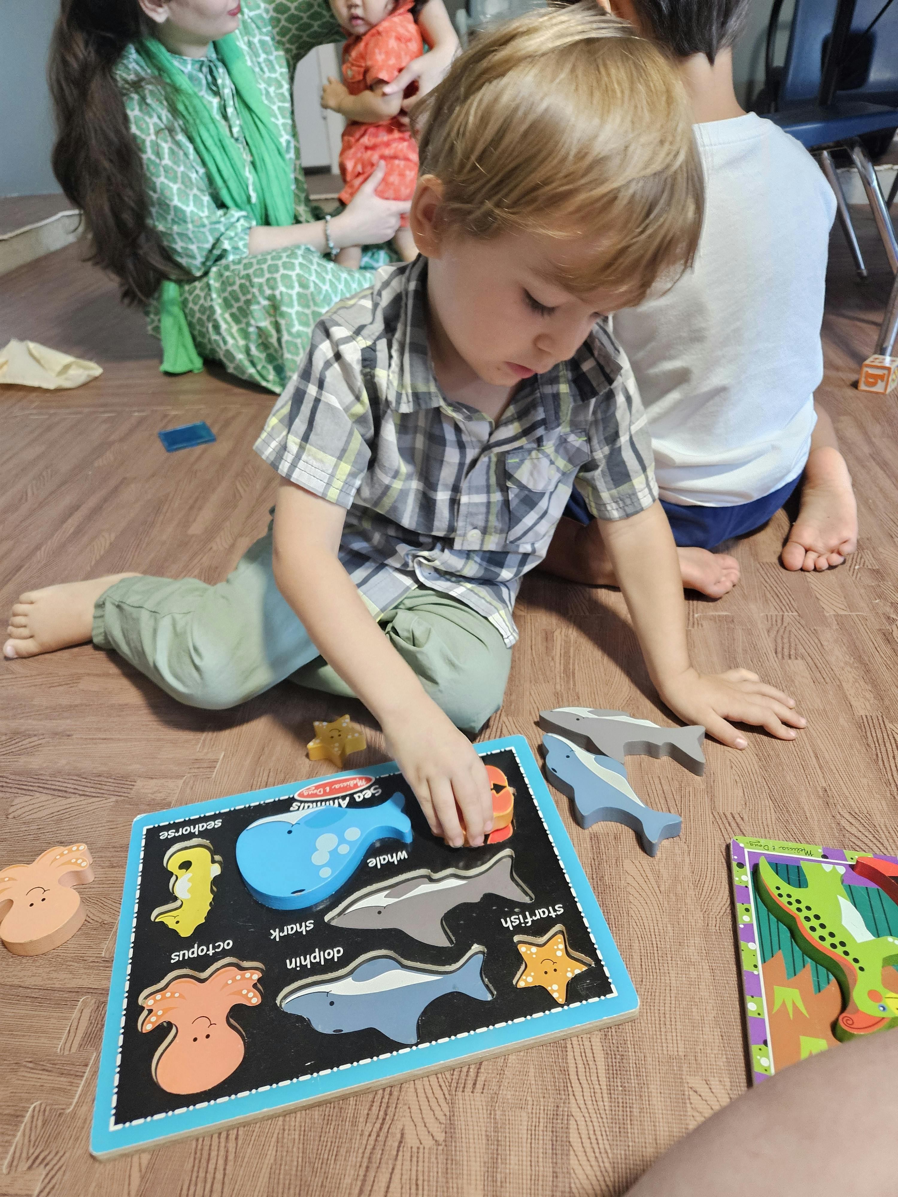 Child playing with a sea animal puzzle on the floor