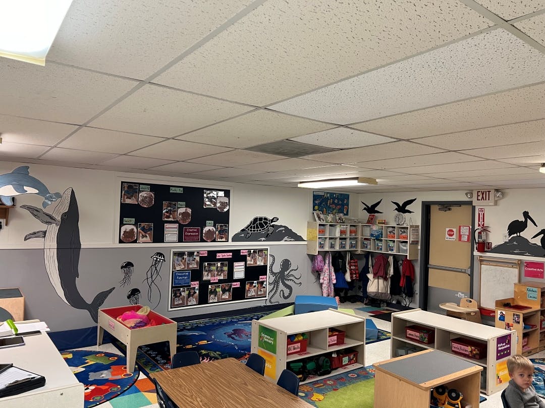 Classroom decorated with ocean murals and child in bottom right corner