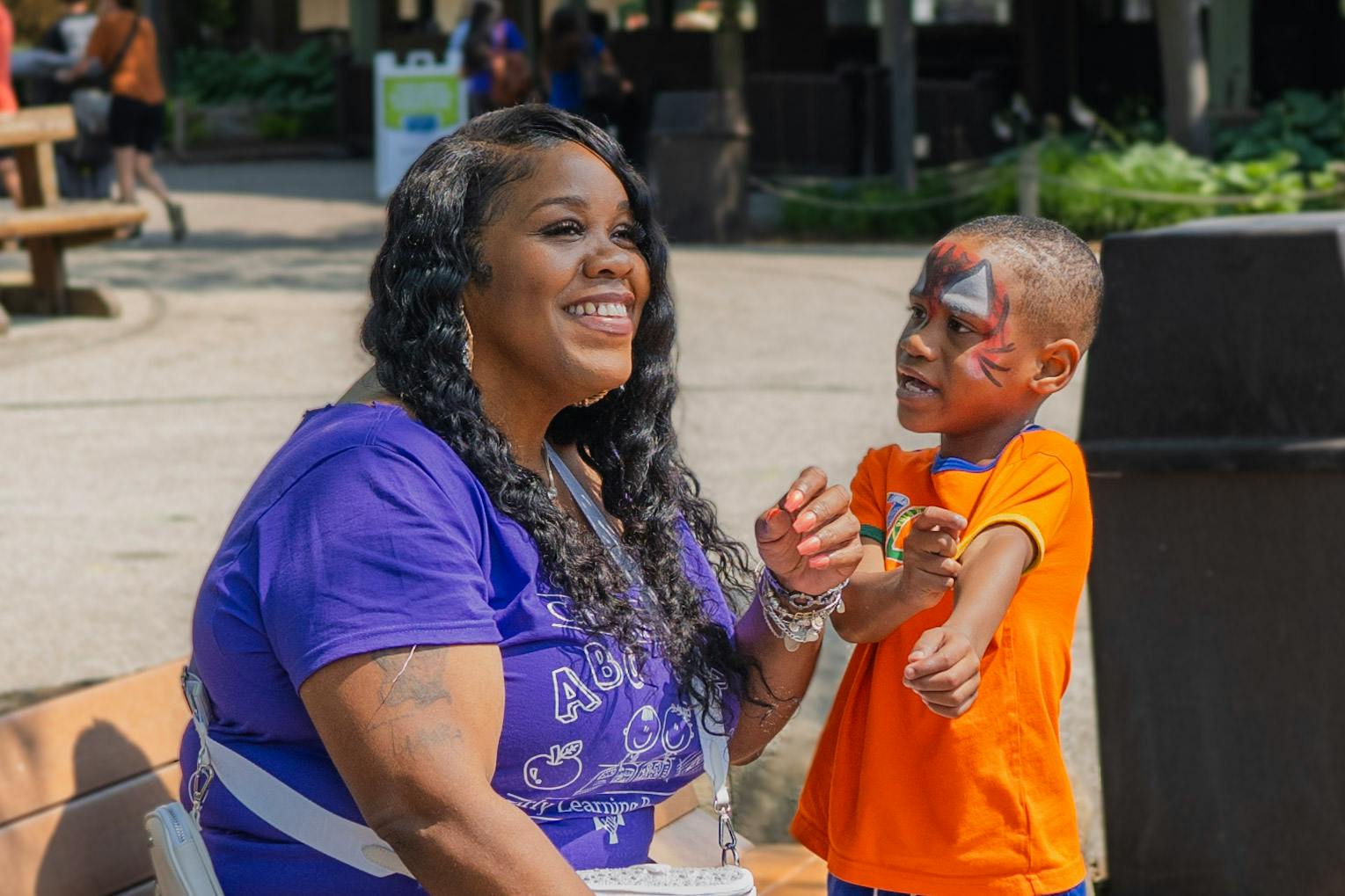 Person smiling at a child with face paint