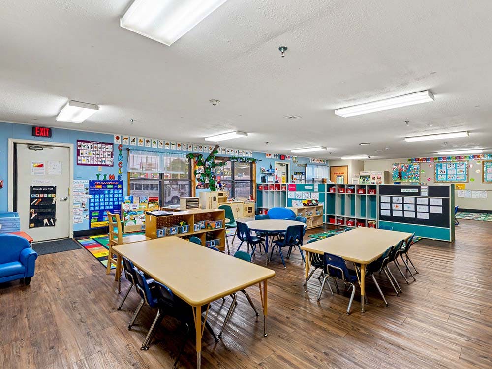 Empty classroom with small tables and chairs