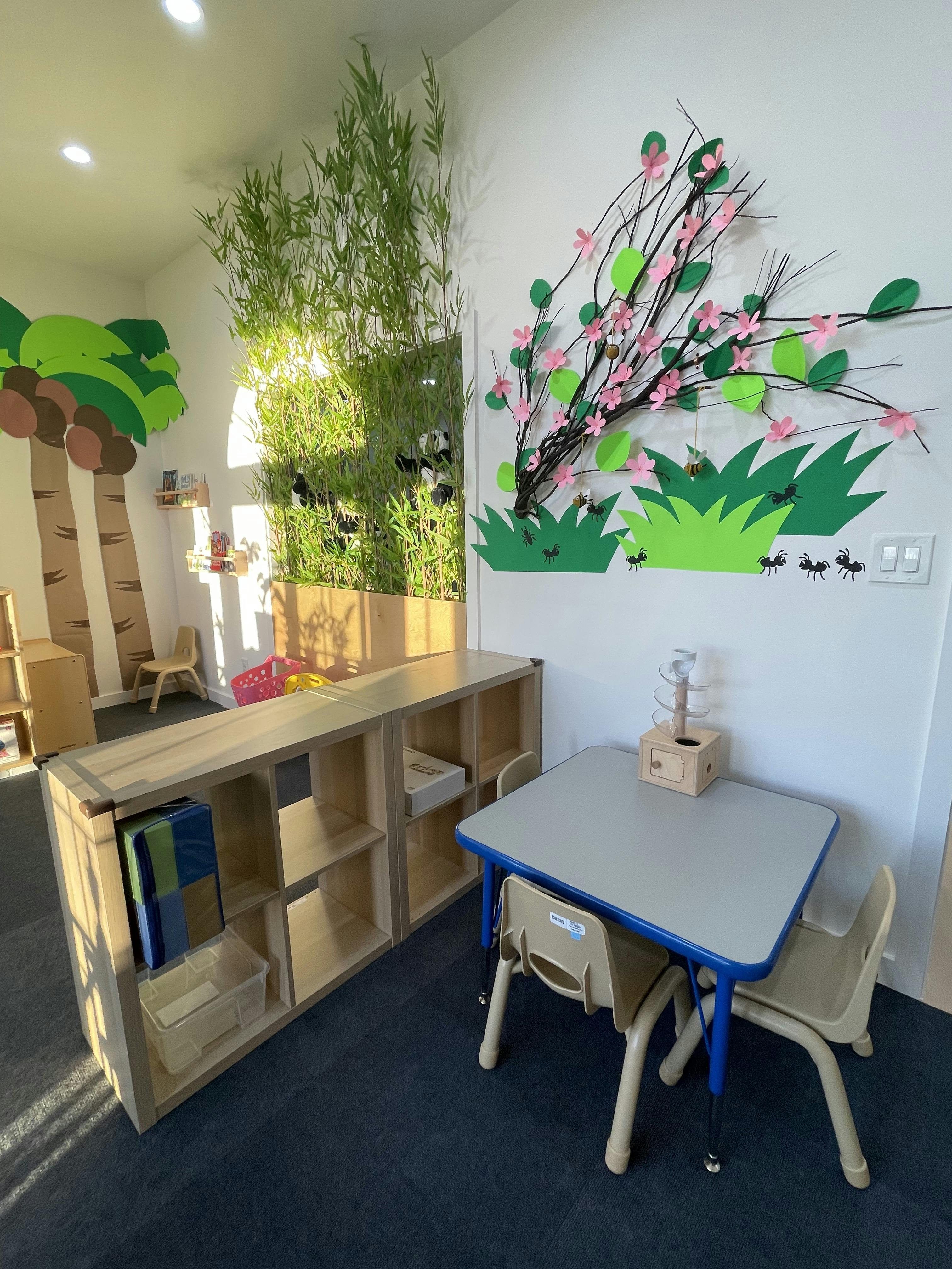 Classroom with a small table and chairs, shelving unit, and wall decorations