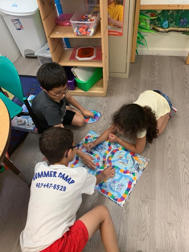 Three children playing a board game on the floor