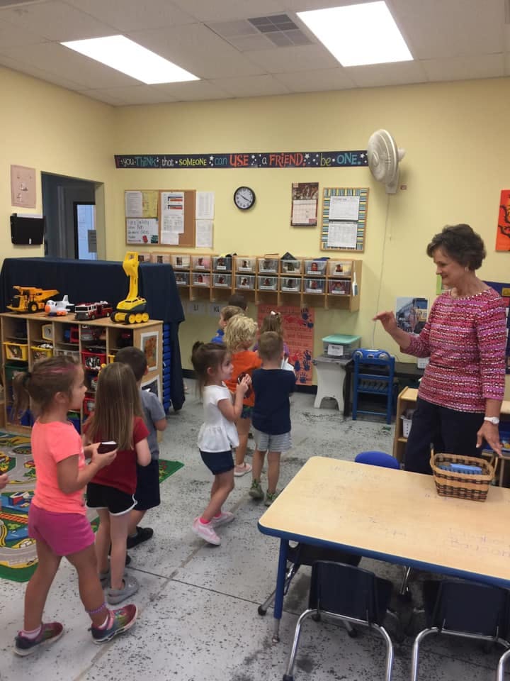 Adult person interacting with children in a classroom