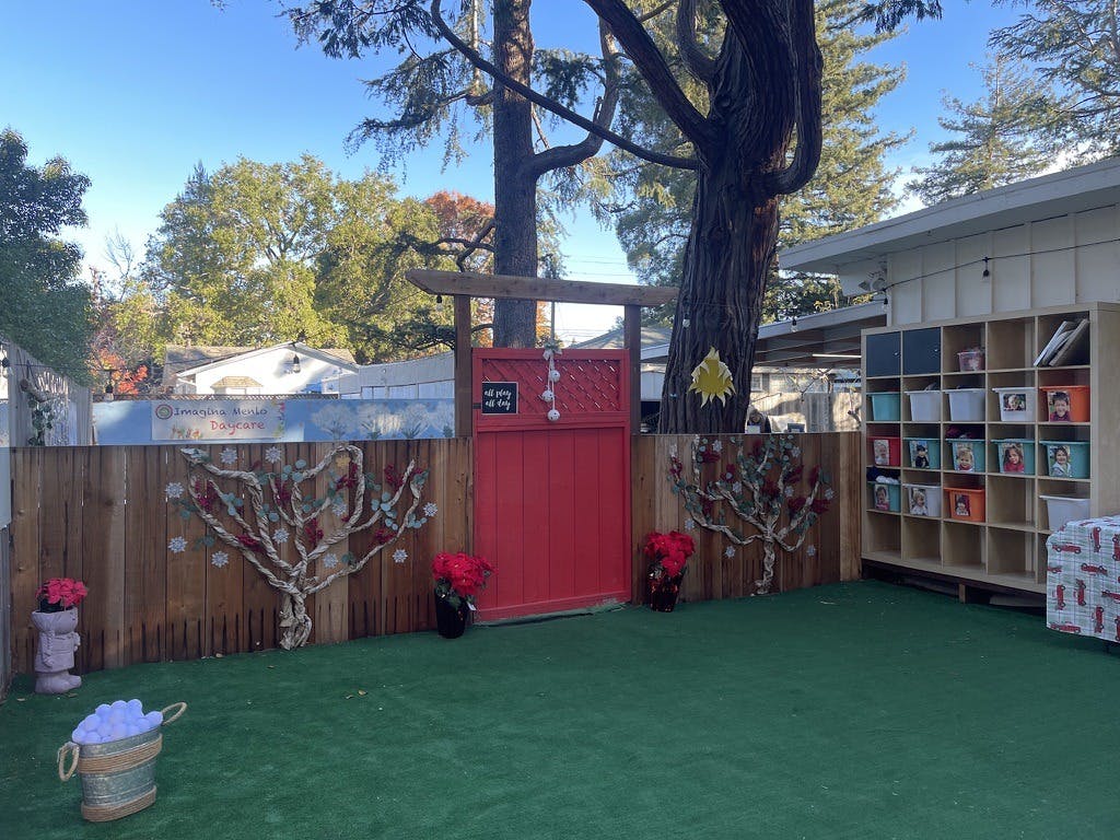 Outdoor play area with red gate and storage cubbies at Imagina Menlo Daycare