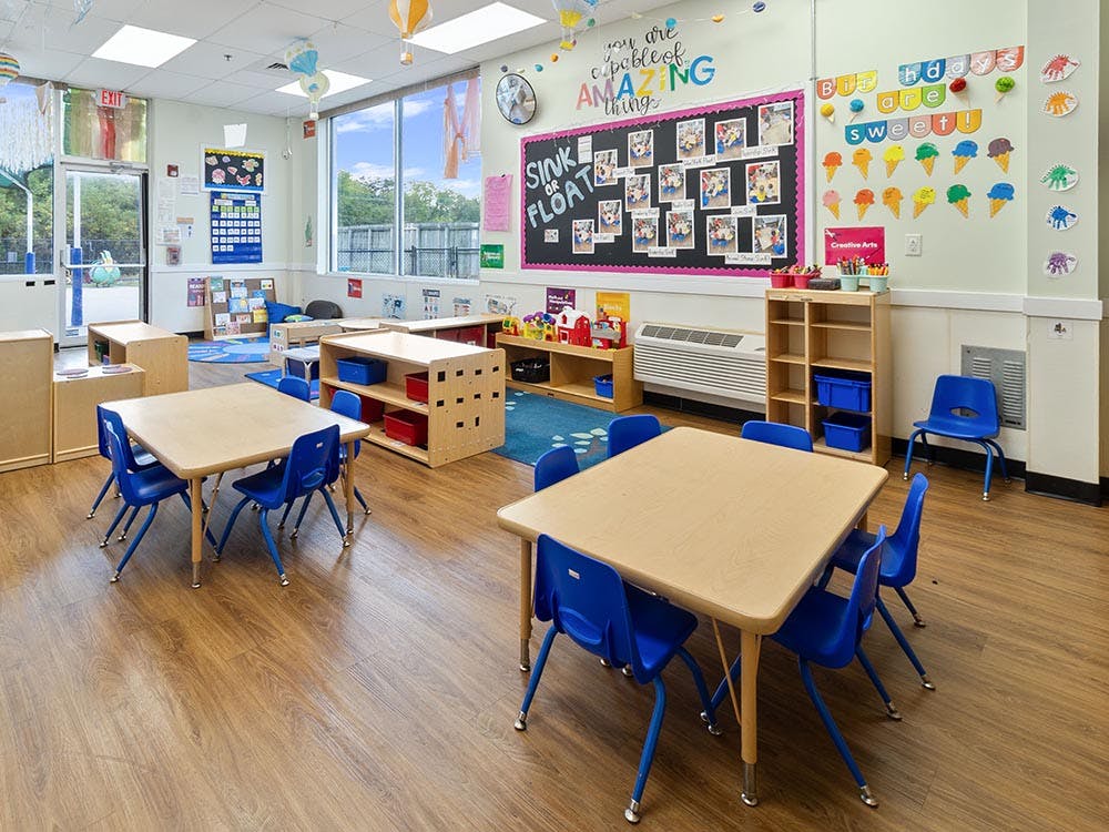 Empty classroom with small tables and chairs, and colorful decorations