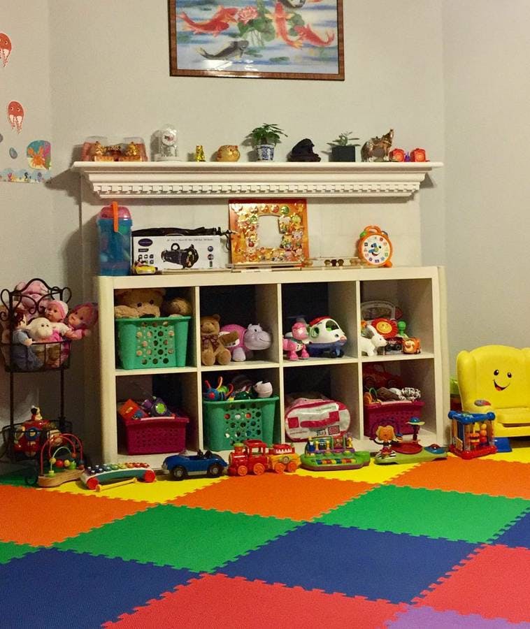 Playroom with colorful floor mats and shelves filled with toys