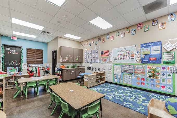 Classroom with tables, chairs, and educational decorations on the walls