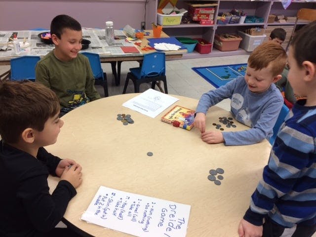 Four children playing a board game at a round table
