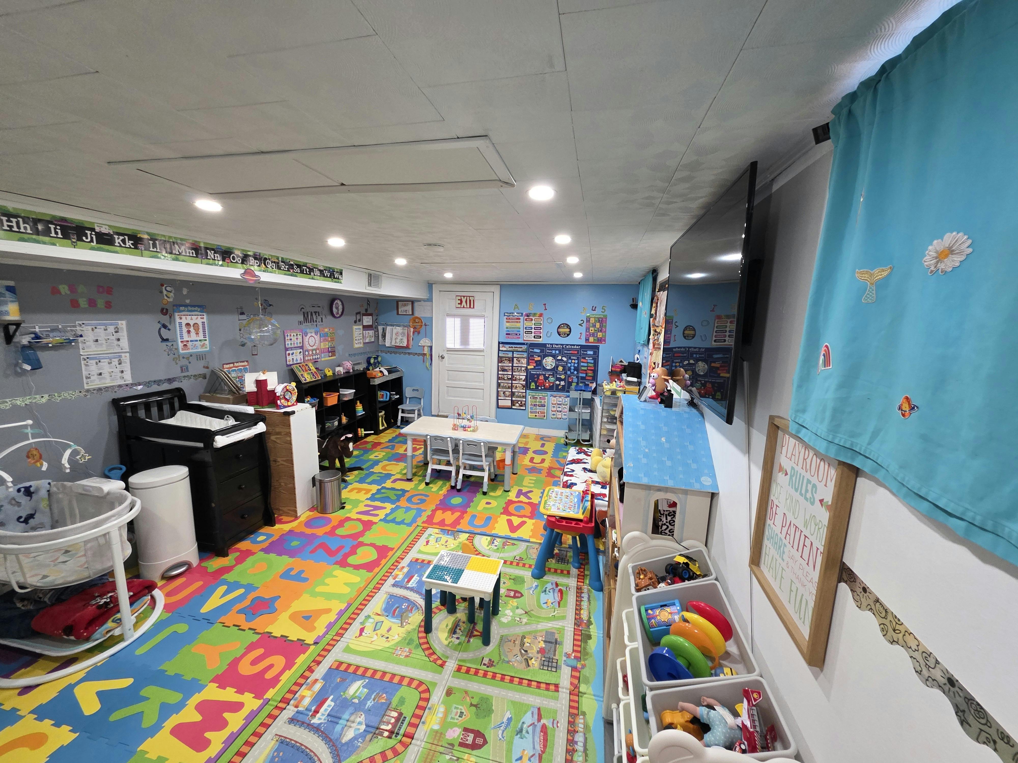 Indoor playroom with colorful alphabet floor mats and various toys