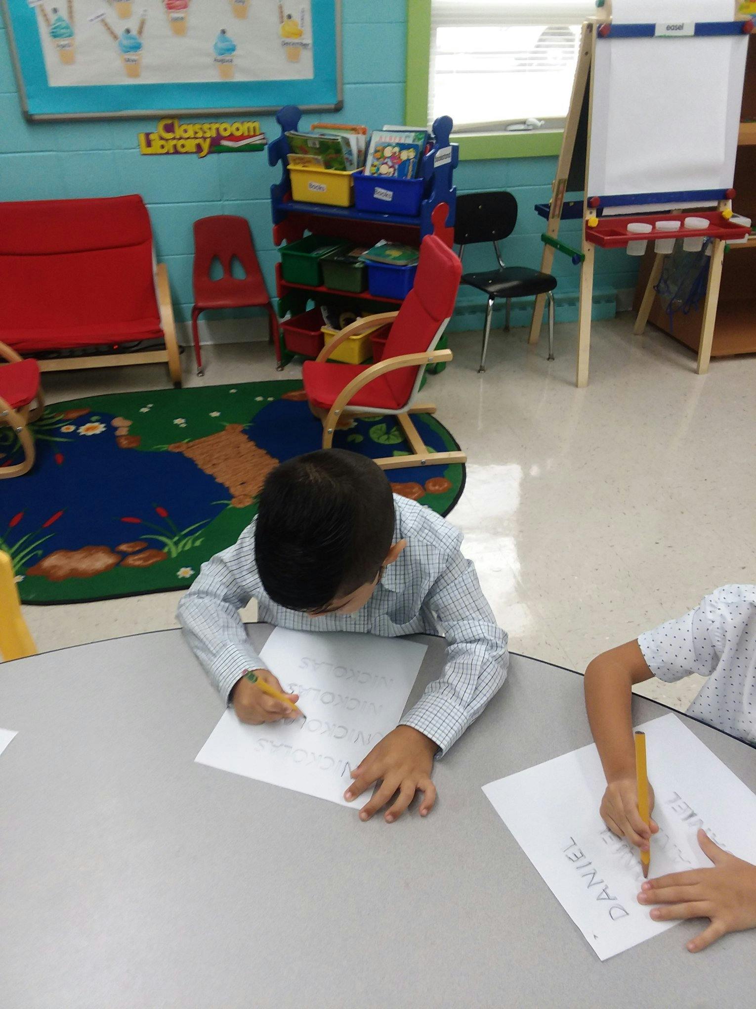 Child drawing at a table in a classroom
