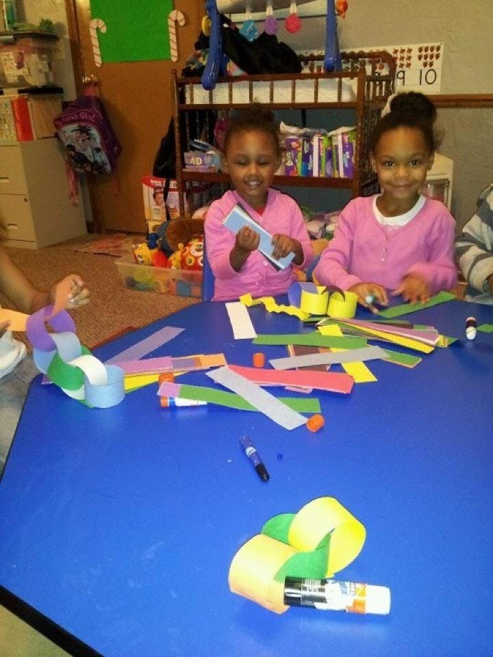 Two children making paper crafts at a table