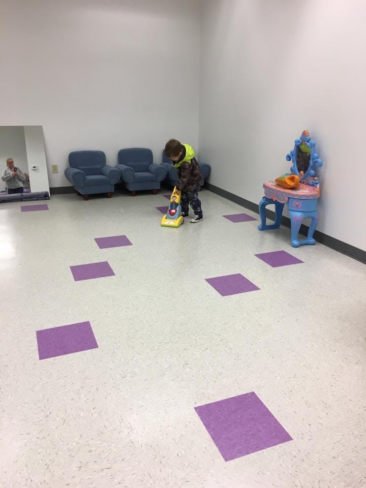 Child playing with a toy vacuum cleaner indoors