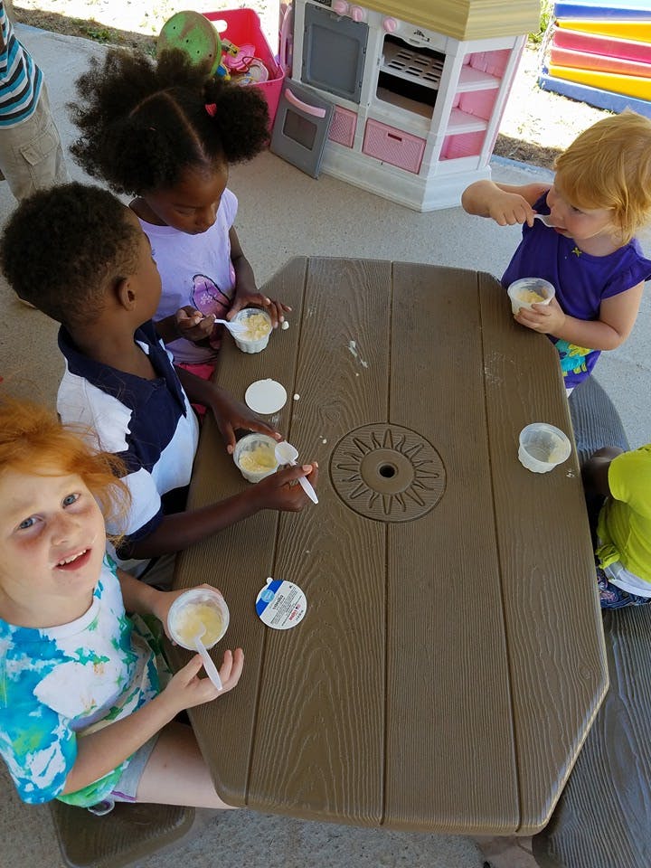 Children eating snacks at a picnic table