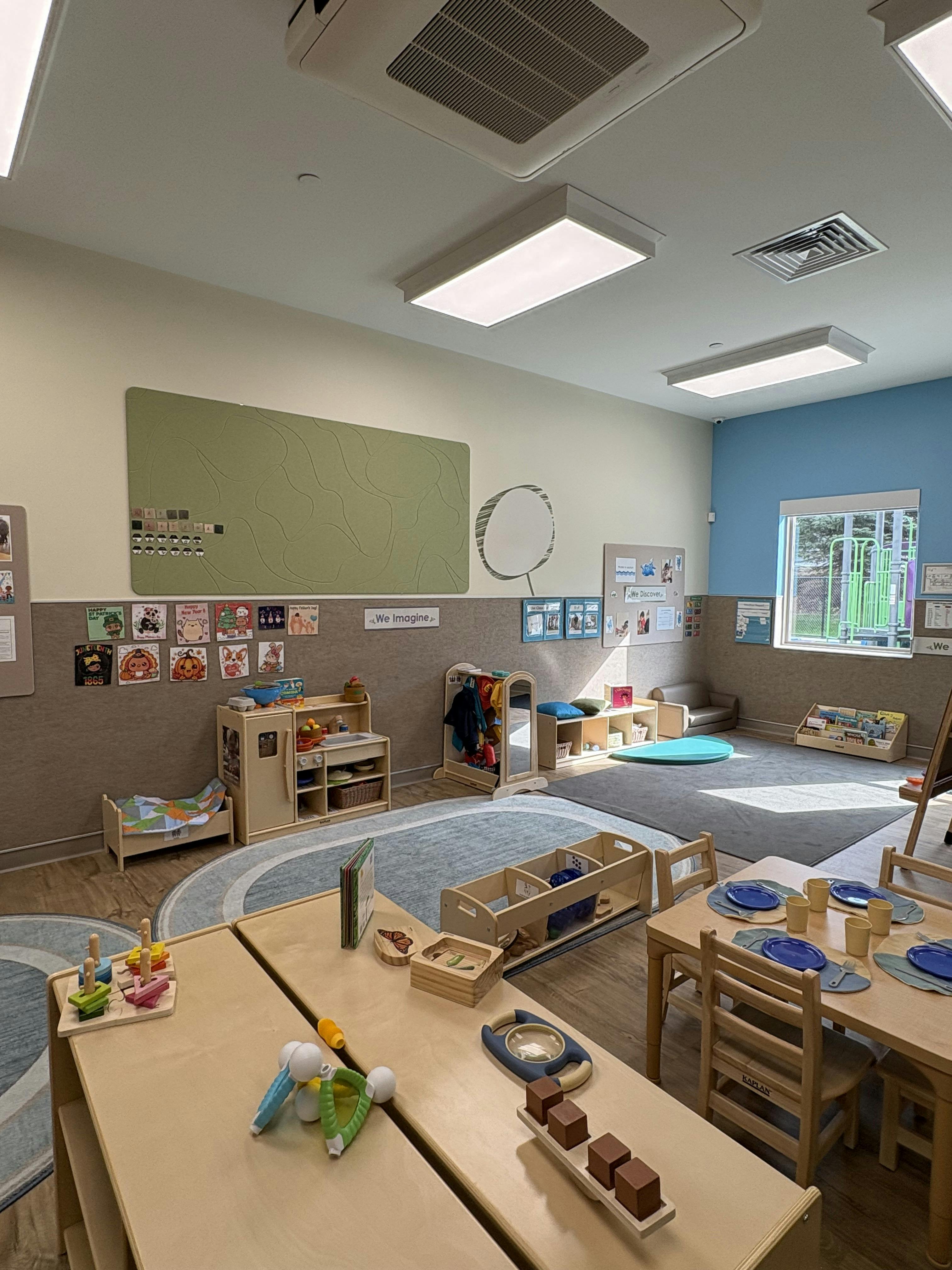 Classroom with small tables, chairs, and play areas