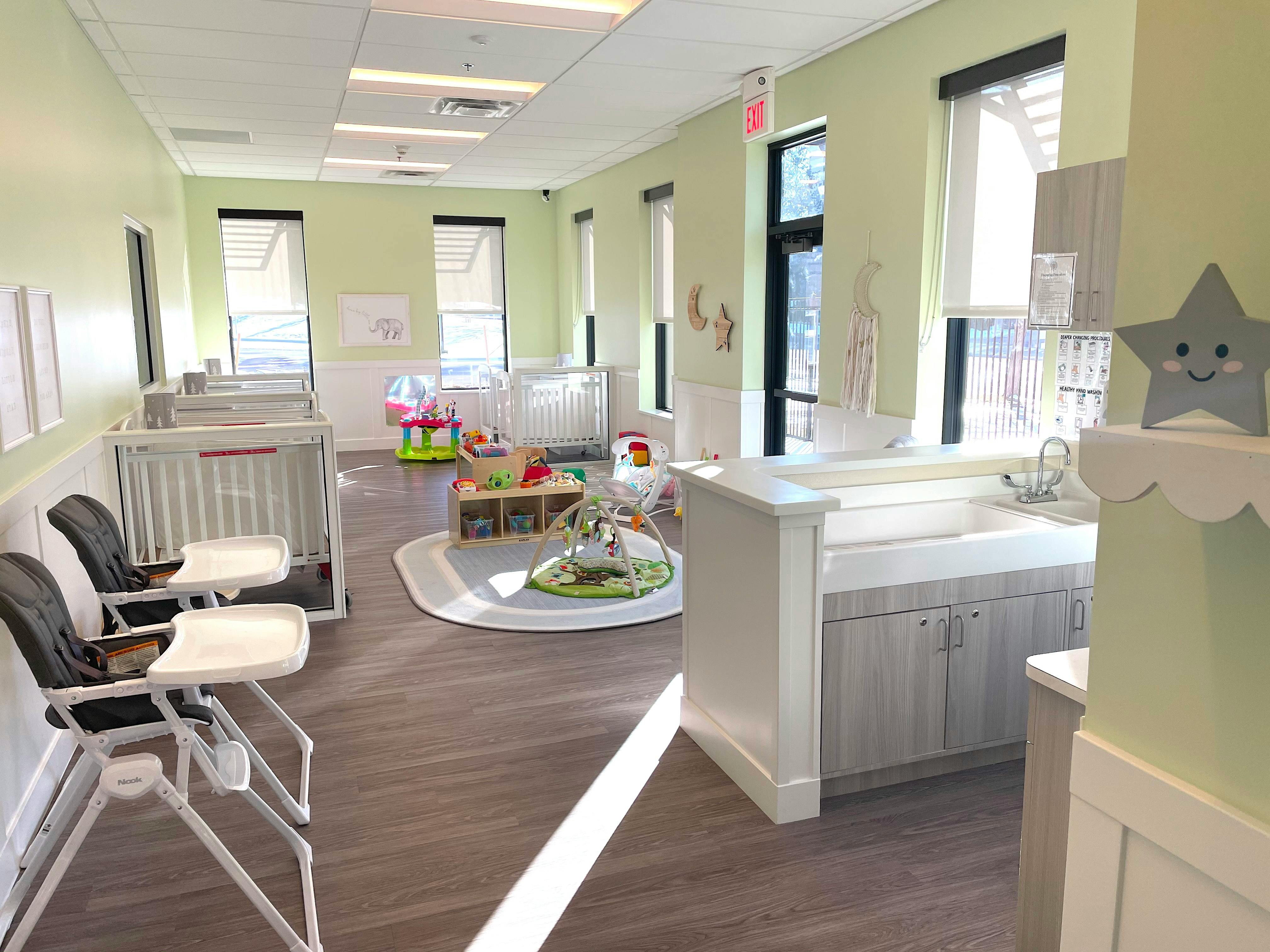 Nursery room with cribs, high chairs, and play mats