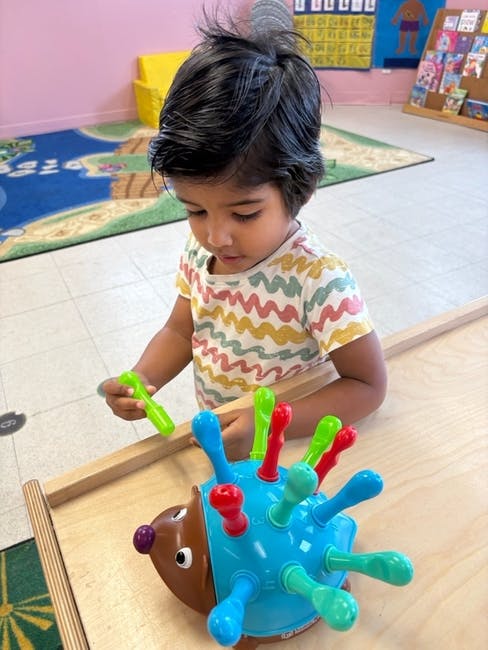 Child playing with a colorful hedgehog toy