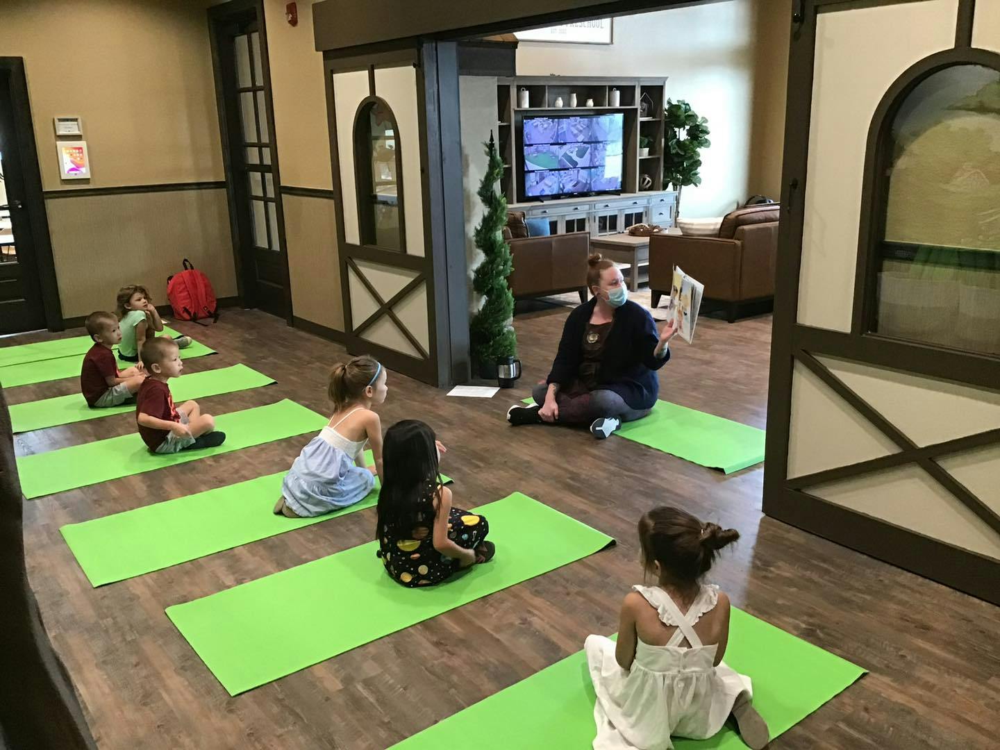 Adult and children sitting on yoga mats