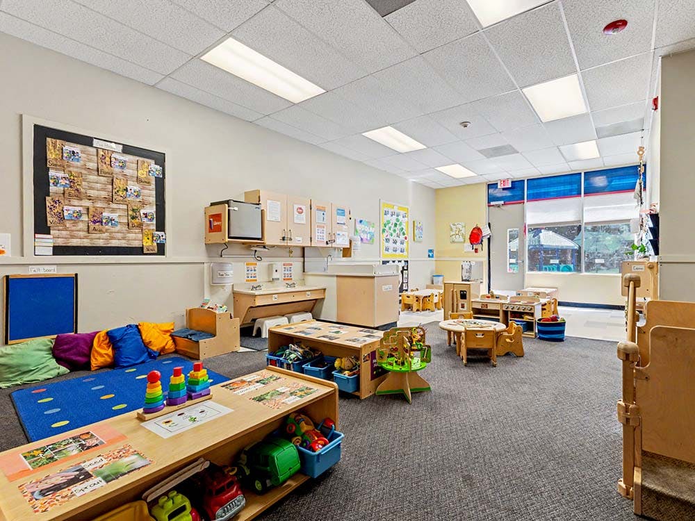 A colorful preschool classroom with small tables, chairs, and toys