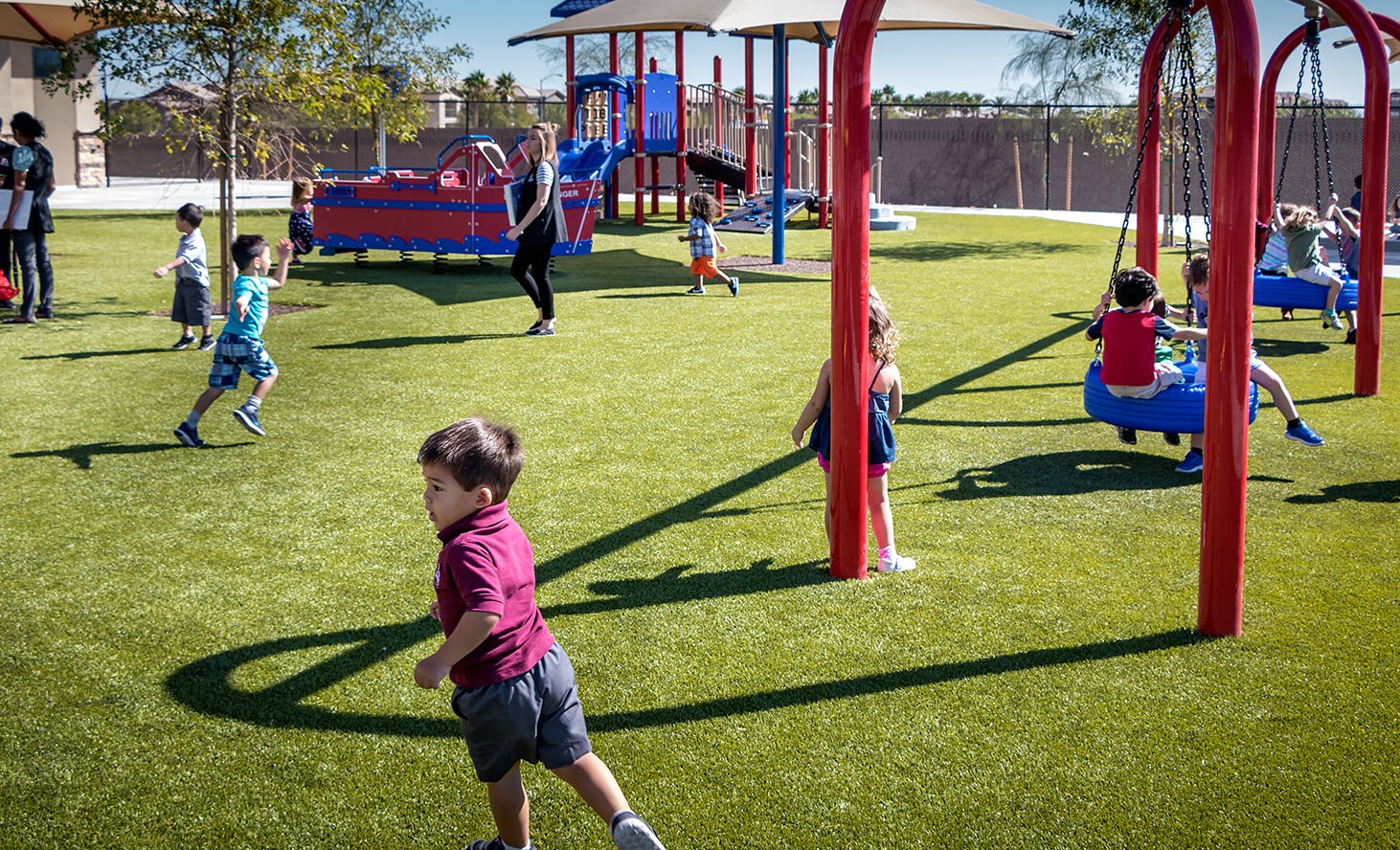 Children playing on a playground with swings and play structures
