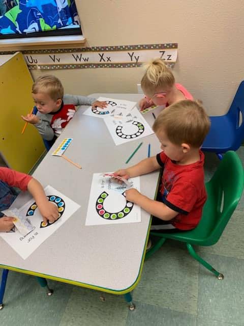 Children sitting at a table working on craft projects
