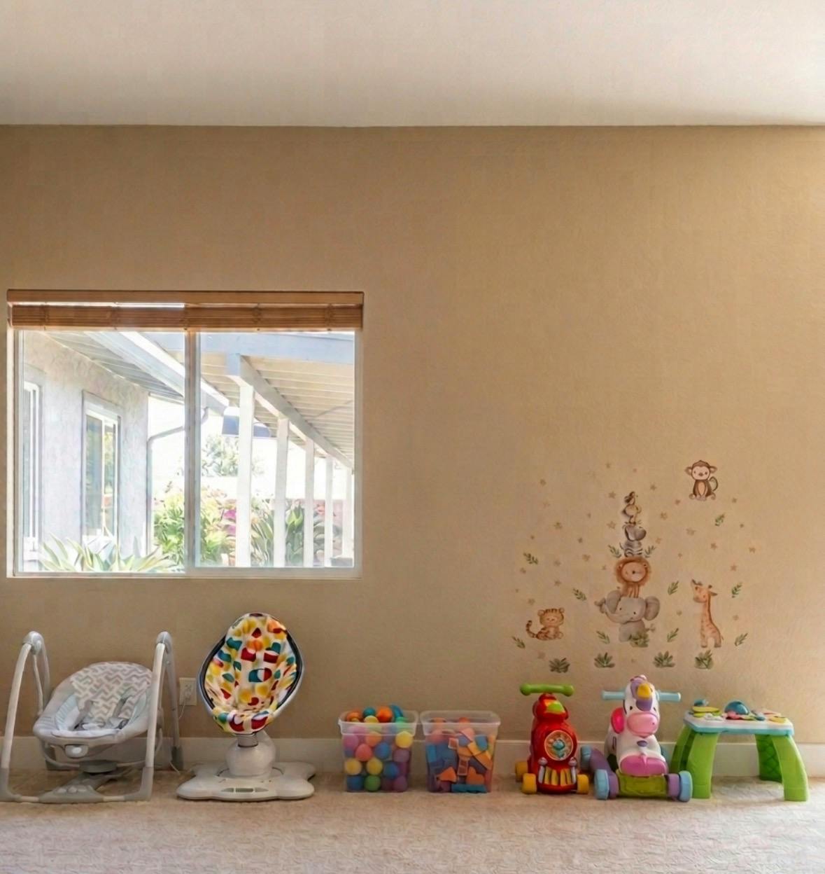 Baby gear and children's toys arranged along a wall in a room