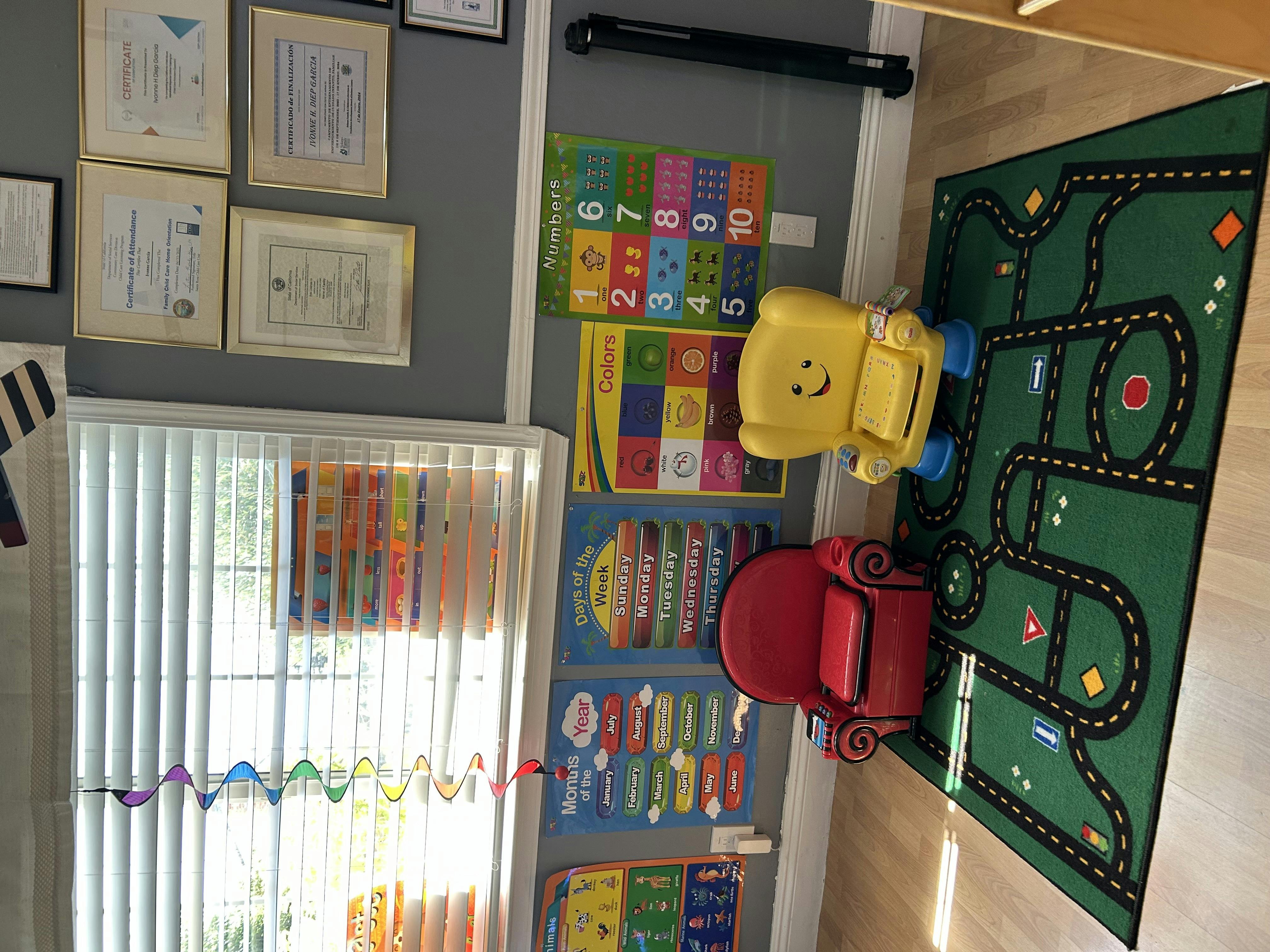 Child's play area with a green road rug and two small chairs