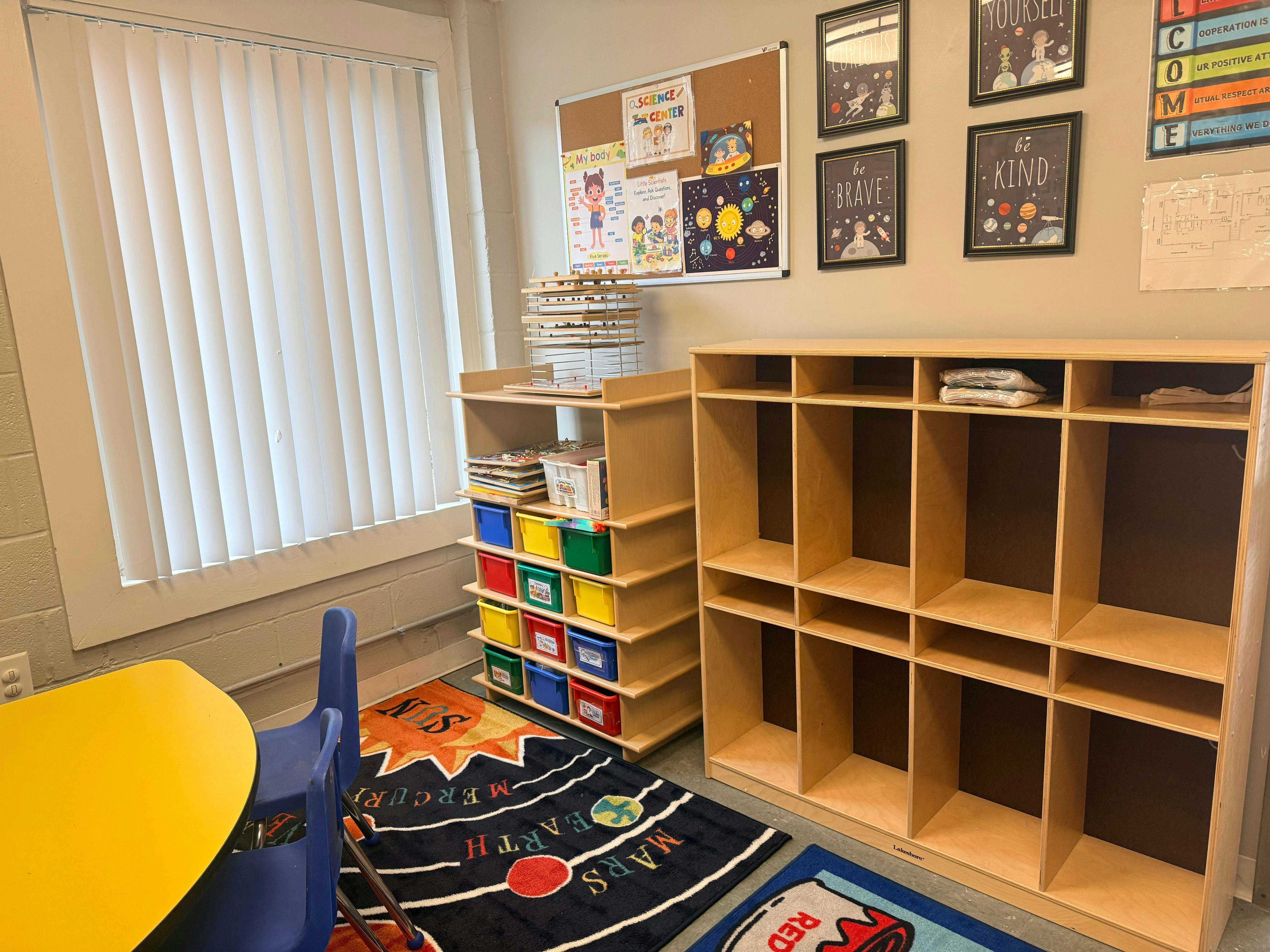 Classroom interior with cubbies and a space-themed rug