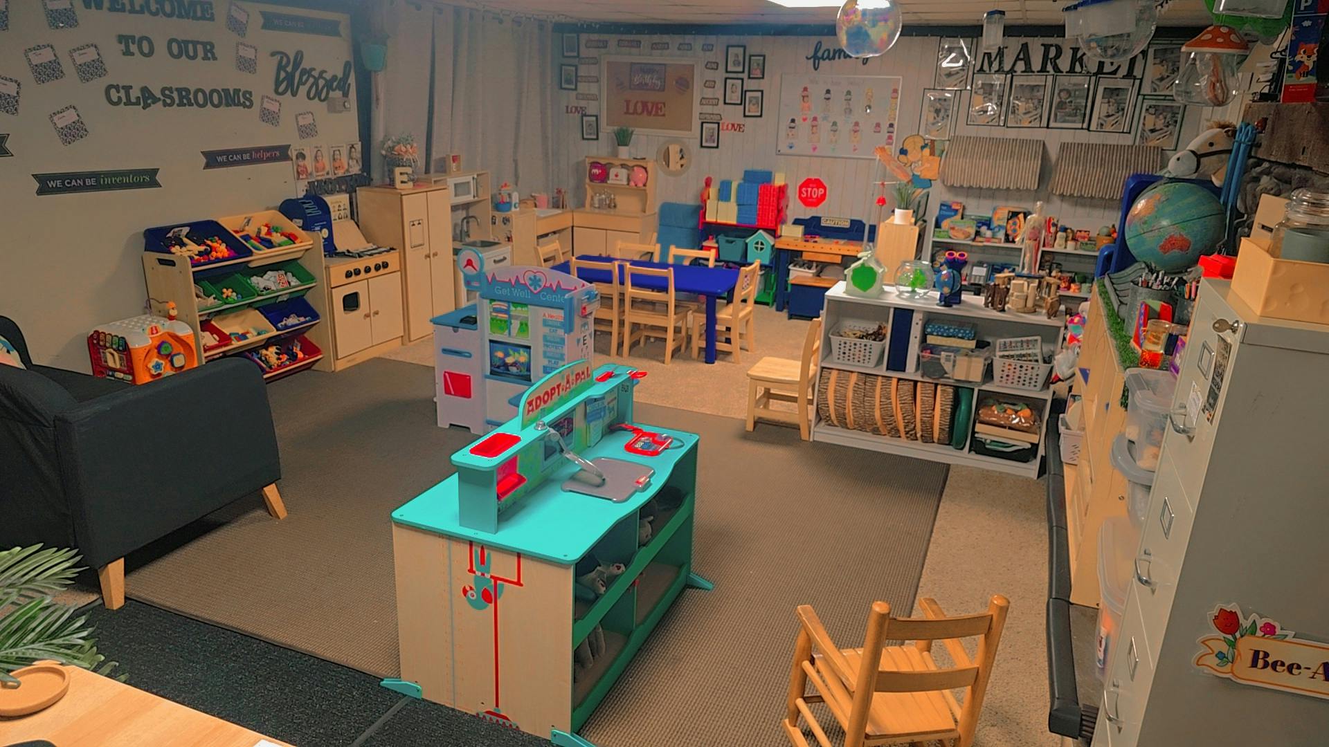 Playroom with toy kitchen, shelves, and small tables