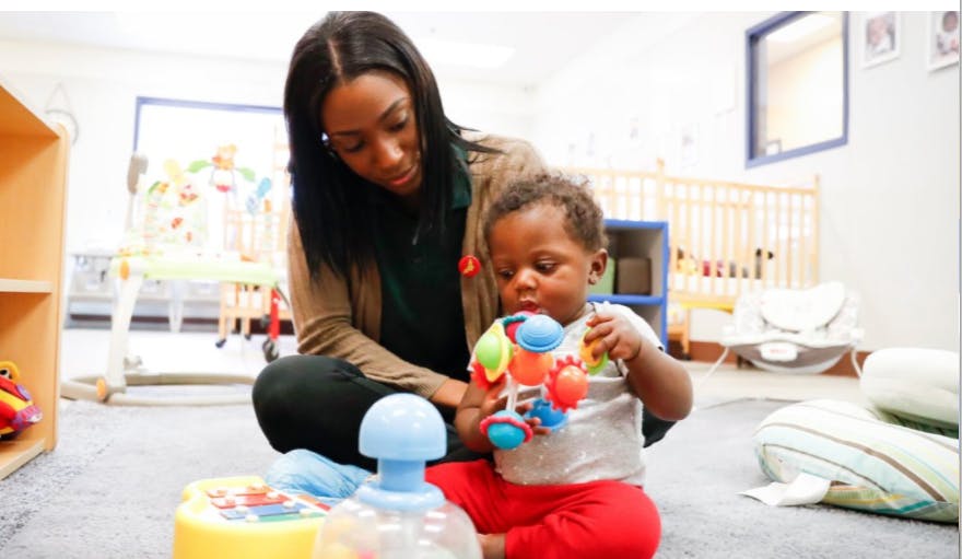Person and child playing with toys on the floor
