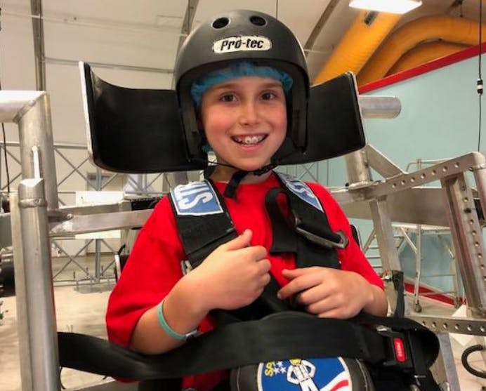 Child wearing a helmet and harness