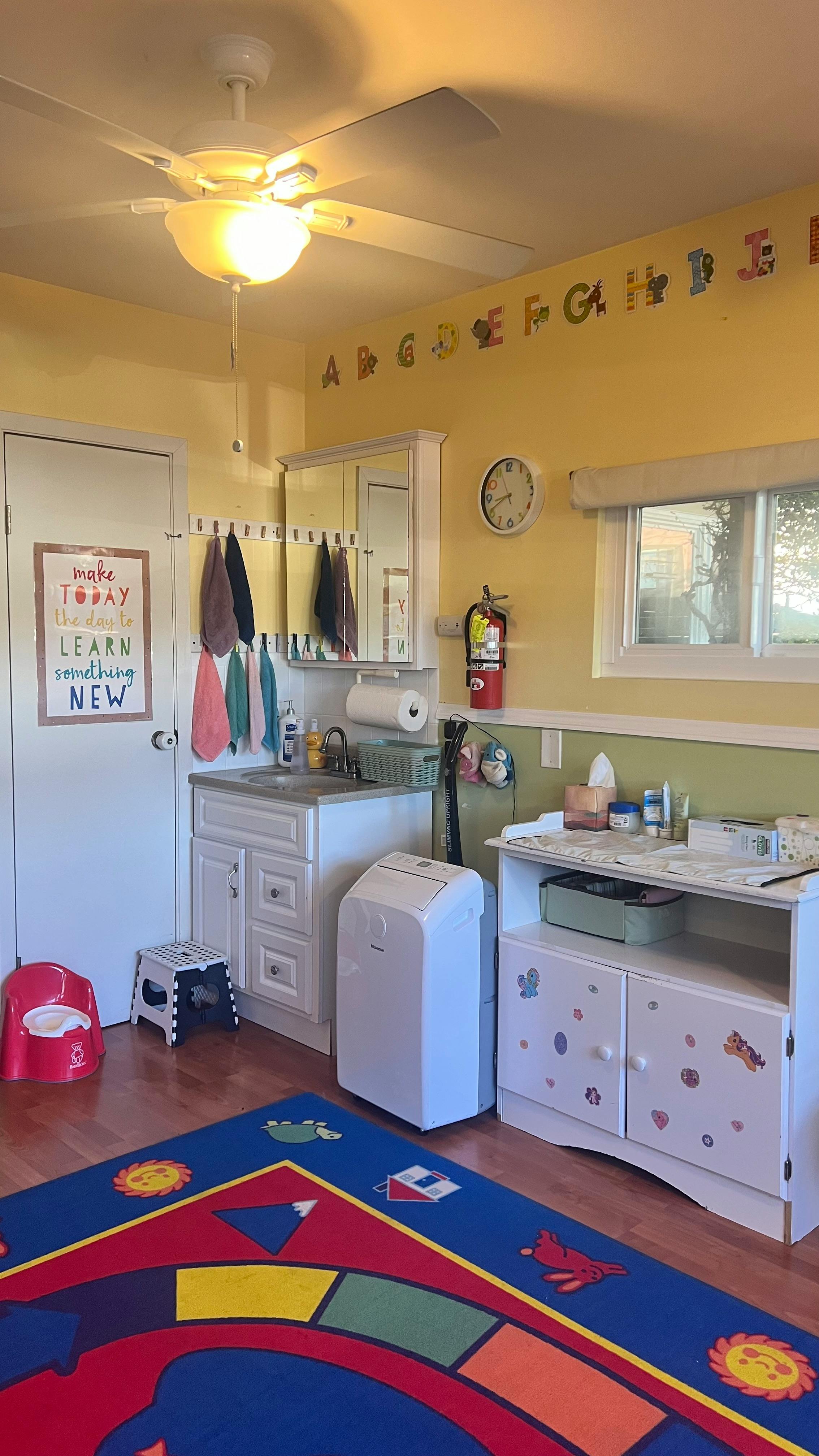 Classroom with sink, changing table, and colorful rug