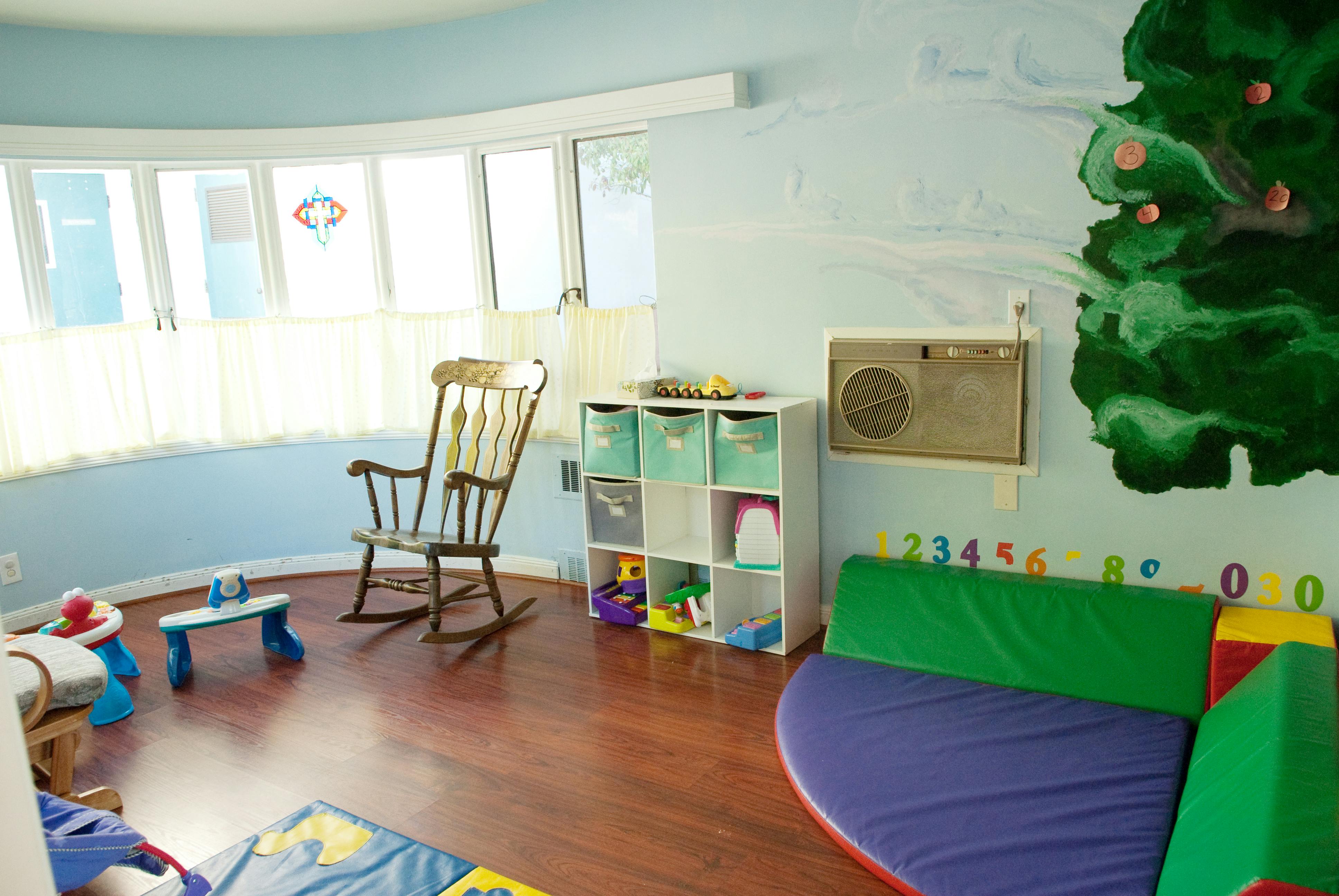 Playroom with a rocking chair, toy storage, and soft play equipment