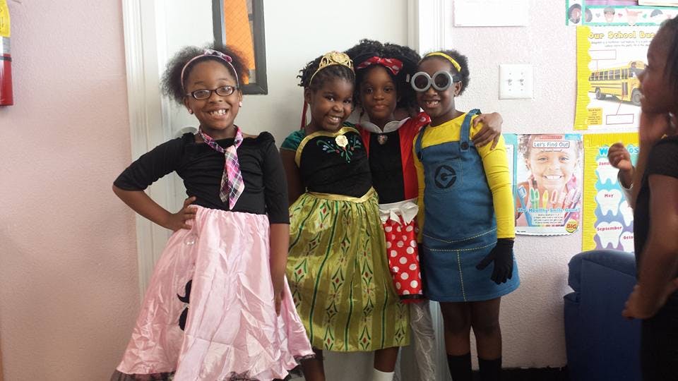 Four children in costumes posing together