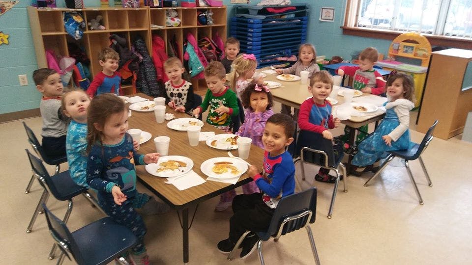 Children sitting at tables in a classroom