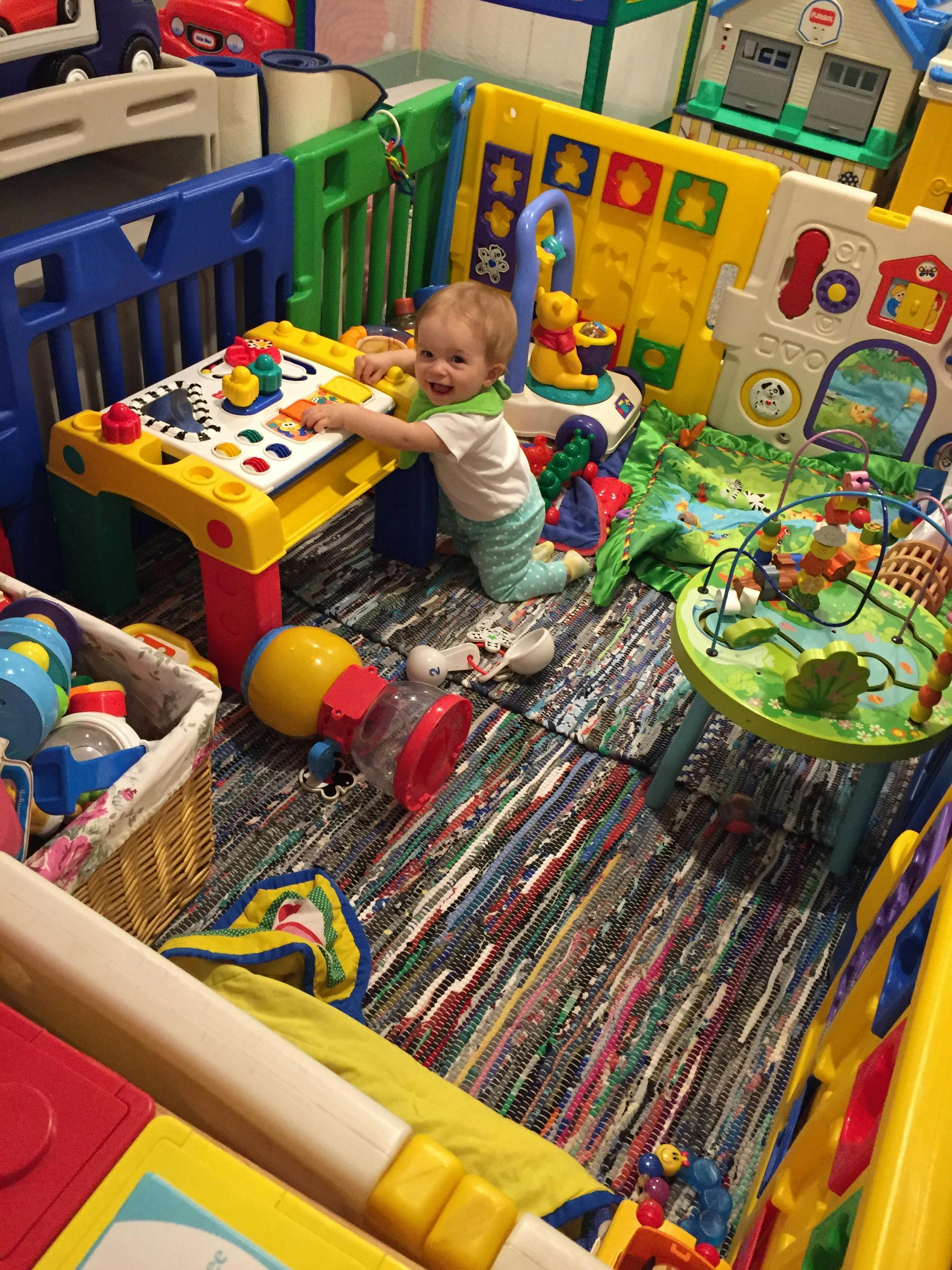 Child playing with a colorful activity table in a play area
