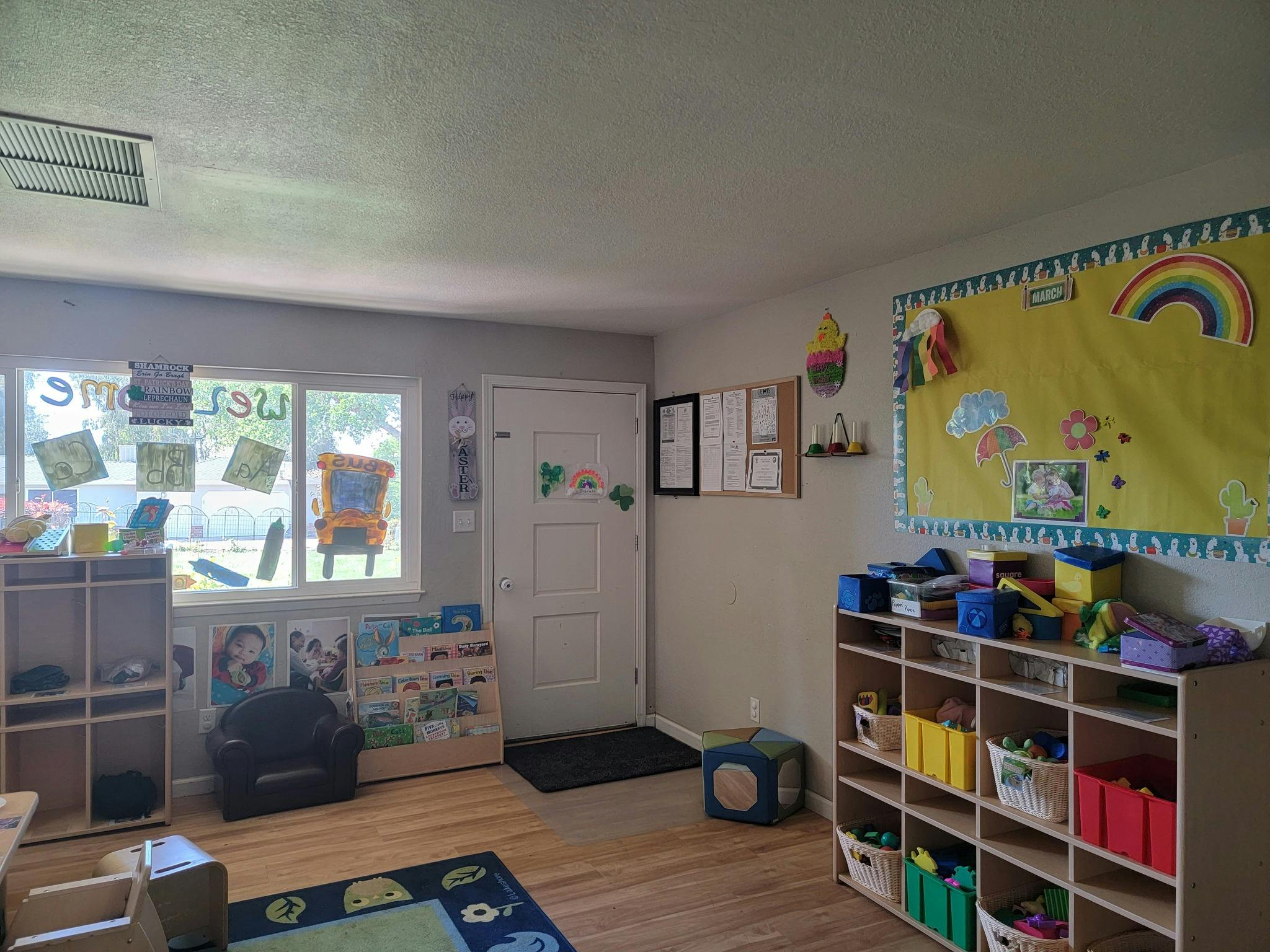 Classroom with windows, a door, and shelves with toys