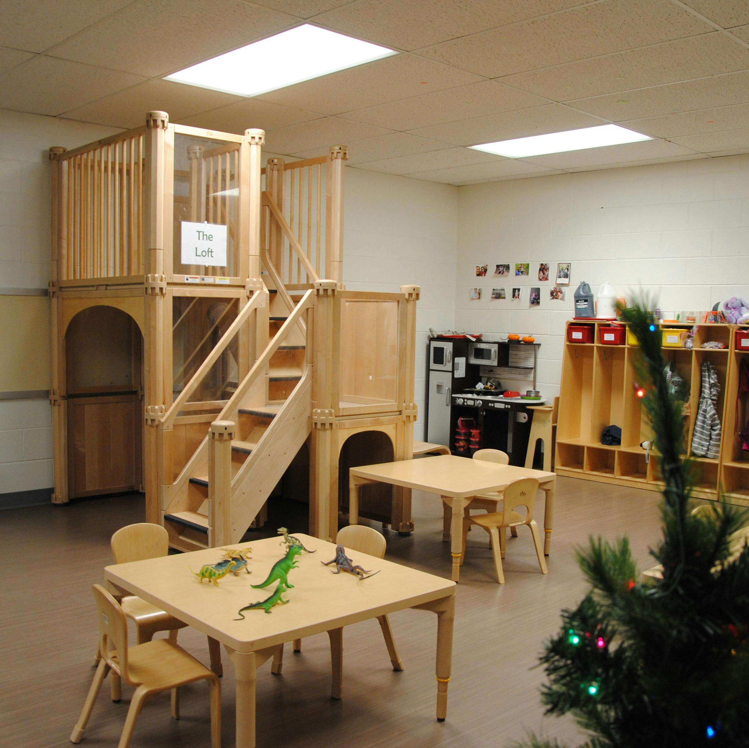 Indoor play structure with stairs and tables in a classroom
