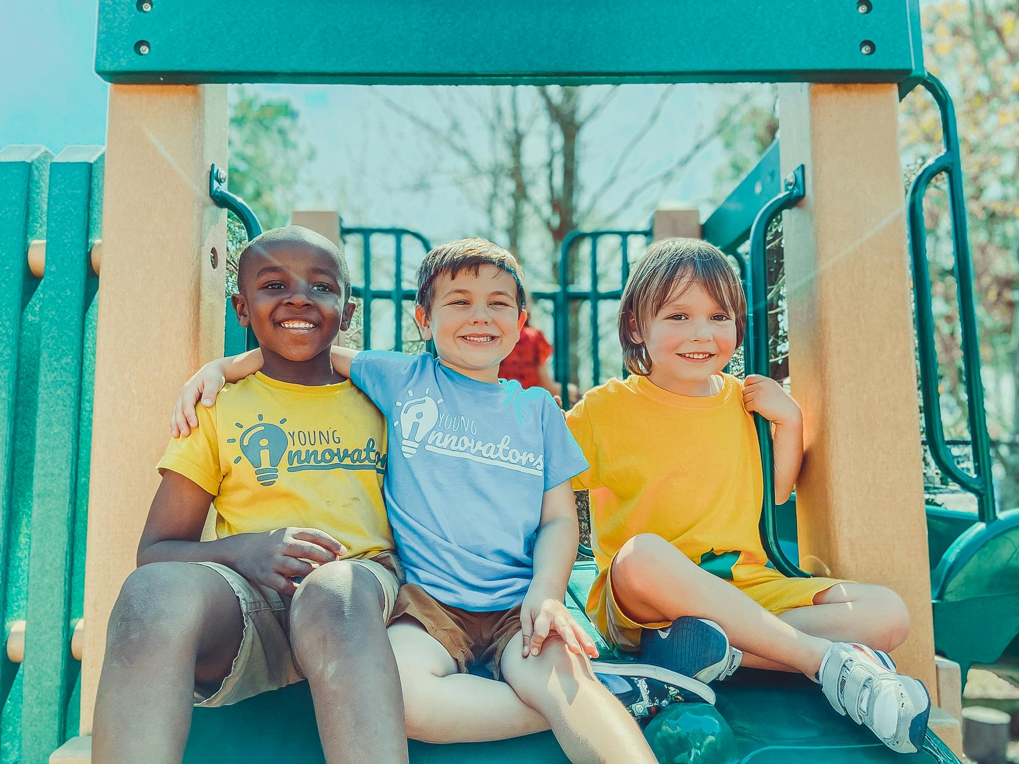 Three children sitting on a playground structure