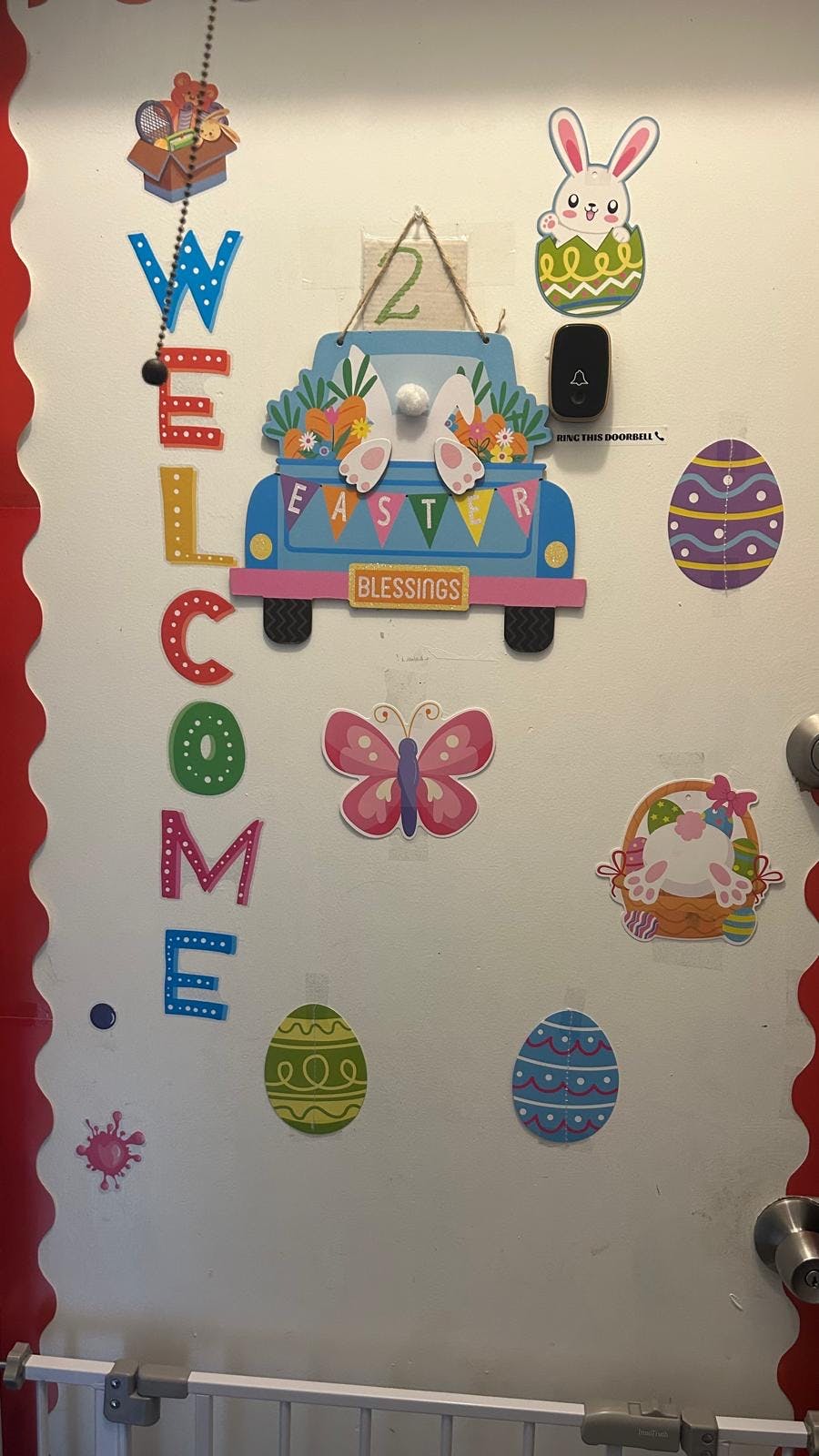 Door decorated with "WELCOME" spelled out vertically and Easter themed cutouts