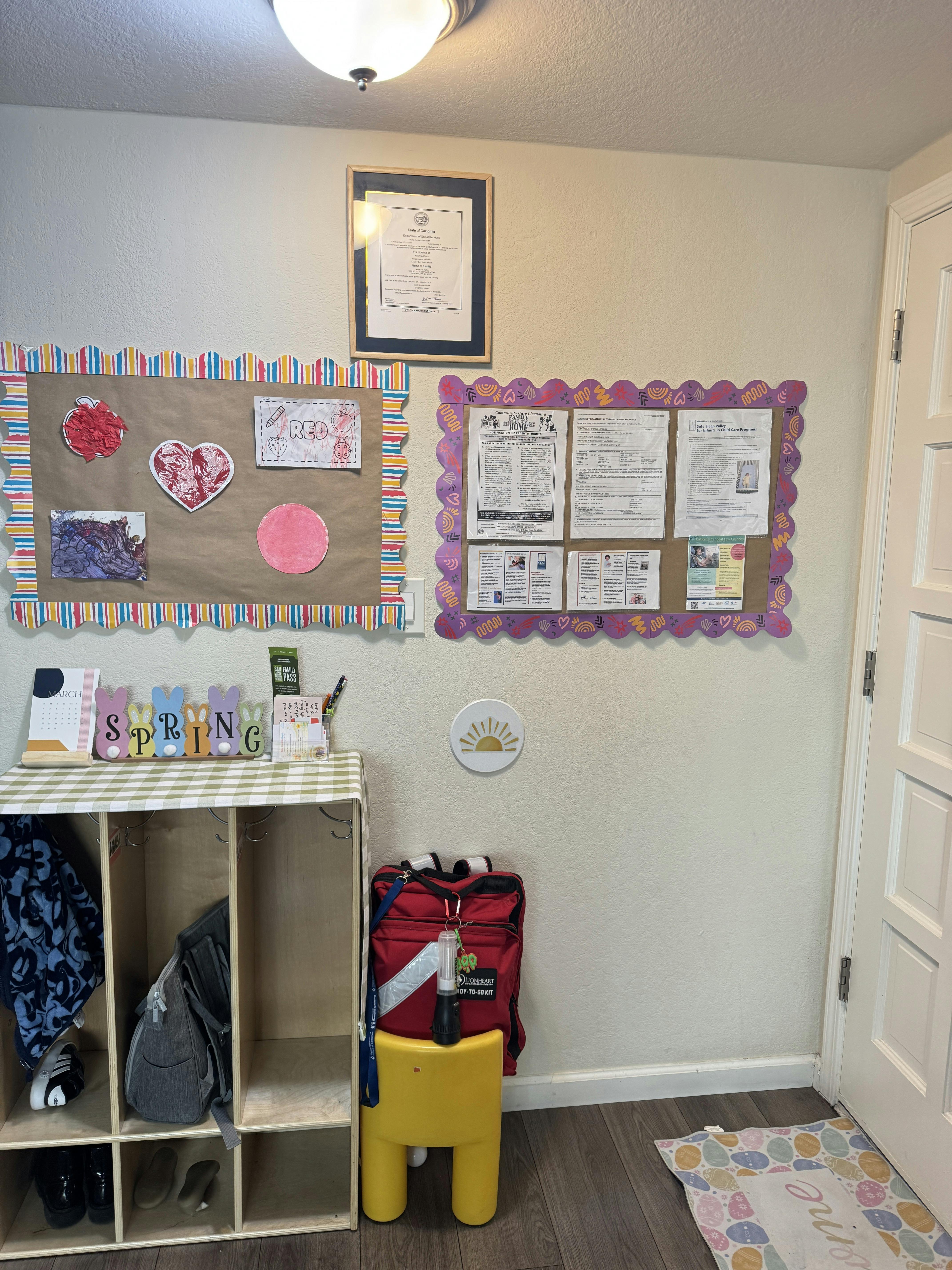Room with cubbies, bulletin boards, and a red emergency kit