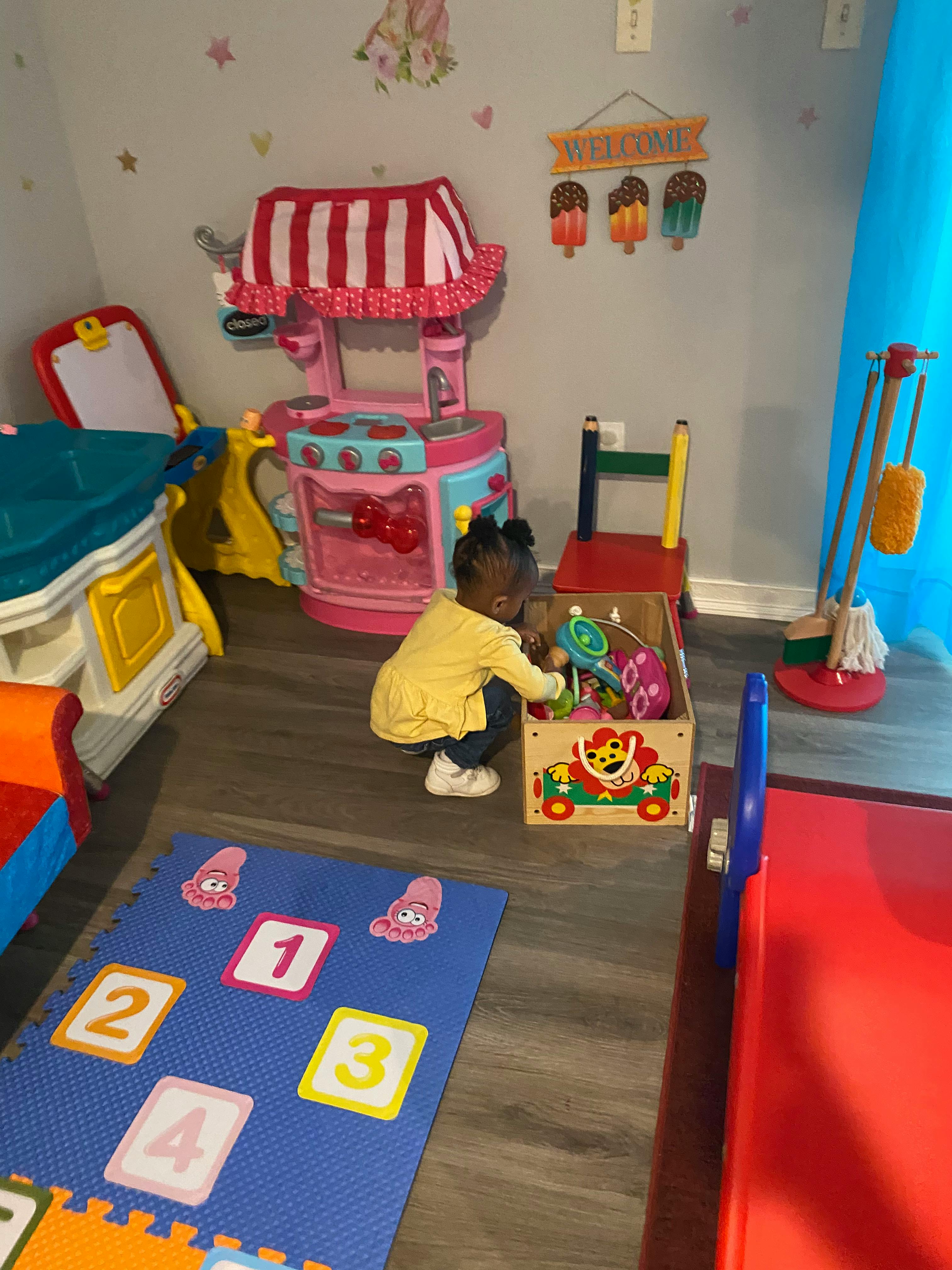 Child playing with toys in a wooden box