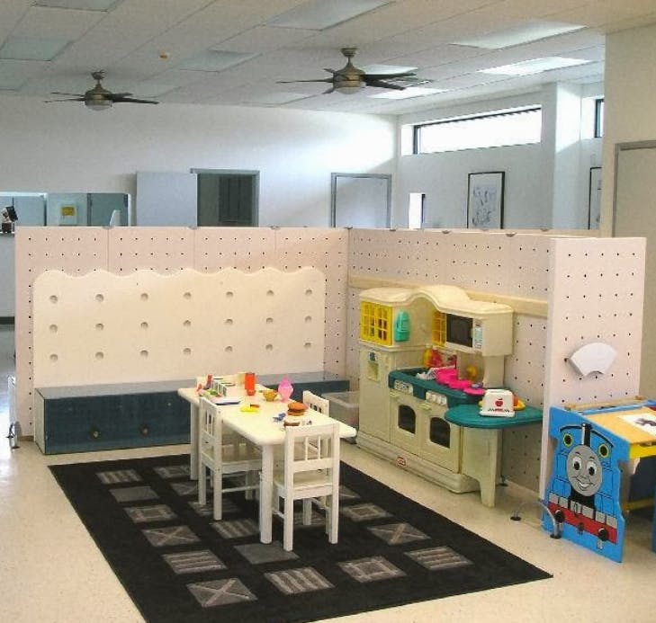 Children's play area with small table and chairs, and a toy kitchen