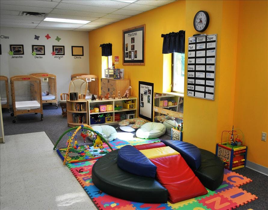 cribs and play area inside a colorful daycare room