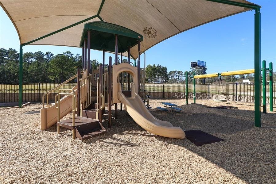 Playground with slides and swings under a shade canopy