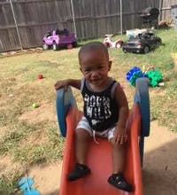 Child sitting on a red slide